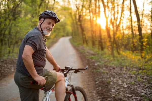 An adult person riding a bicycle outdoors in a calm setting